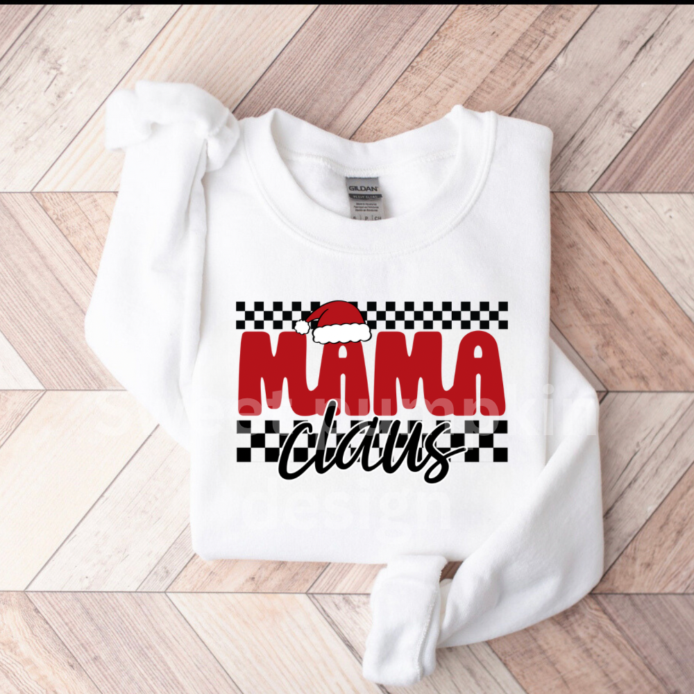 White sweatshirt with 'Mama Claus' text on a wooden floor